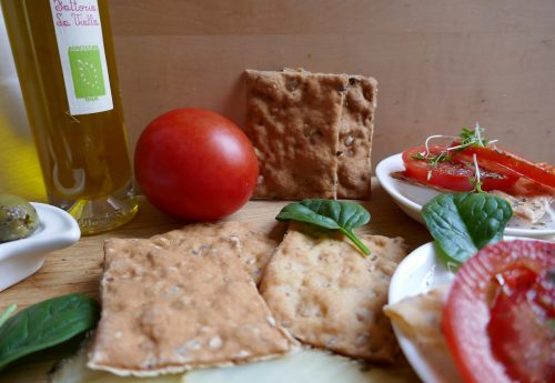 Glutenfreie Ciabattine, Knusprige Cracker von der Fattoria La Vialla--Knusprige Ciabbatine mit Tomate, Oliven und Schafskäse mit Kräuterrand angerichtet
